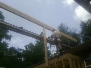 Carpenter setting a ridge beam over a new addition frame — Ice Dam Removal by Roofing Brothers in Cassandra